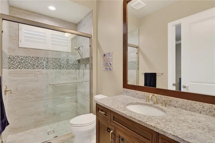 Bathroom vanity with a light granite countertop and undermount sink