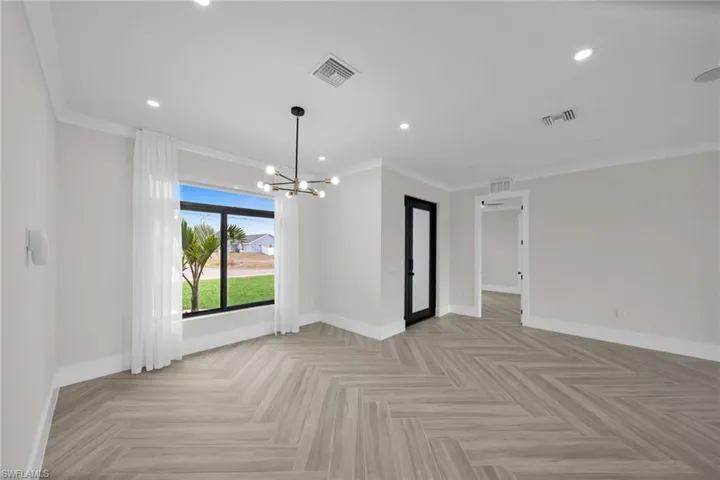 Spare room featuring baseboards, visible vents, and ornamental molding