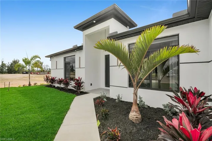 Doorway to property with a yard and stucco siding