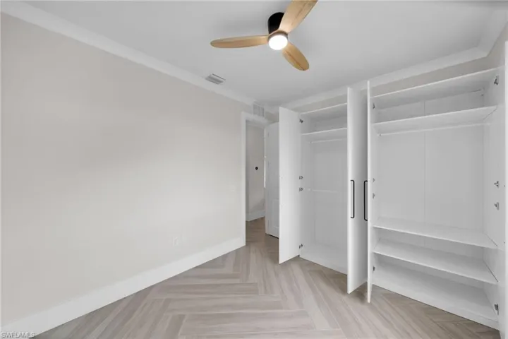 Unfurnished bedroom with visible vents, crown molding, and baseboards