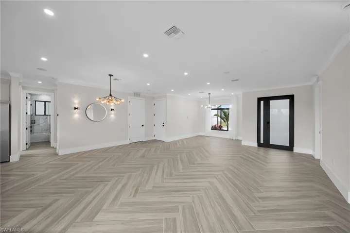Unfurnished living room with baseboards, recessed lighting, visible vents, and a notable chandelier
