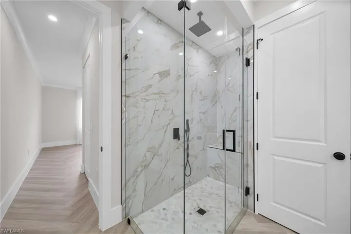 Full bath with recessed lighting, baseboards, and a marble finish shower