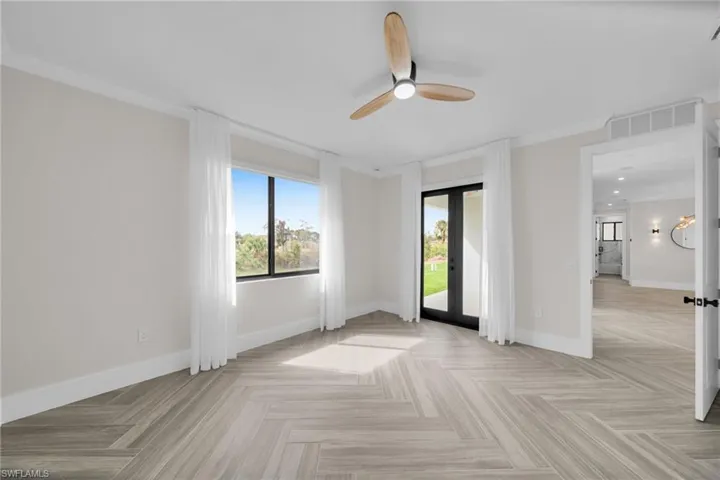 Spare room featuring ceiling fan, visible vents, baseboards, ornamental molding, and french doors
