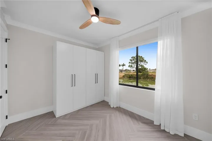 Unfurnished bedroom featuring crown molding, a closet, baseboards, and a ceiling fan