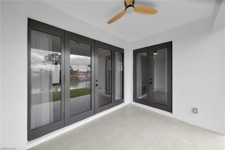 View of patio featuring french doors, a water view, and ceiling fan