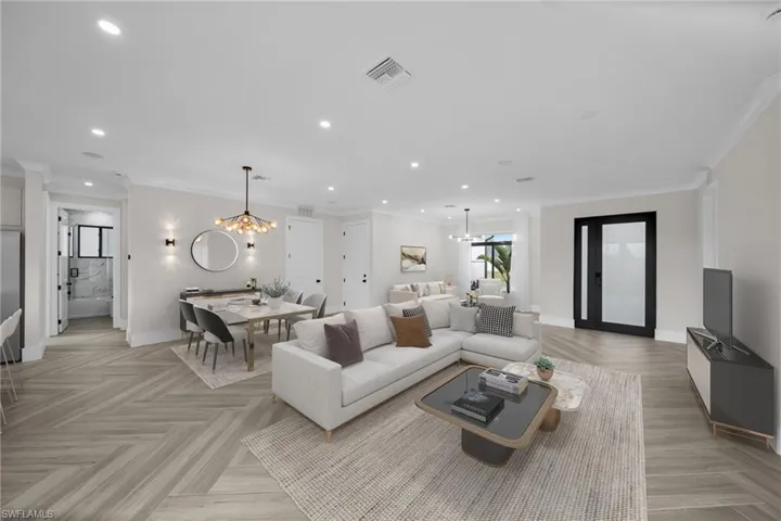 Living area featuring crown molding, recessed lighting, visible vents, and a notable chandelier