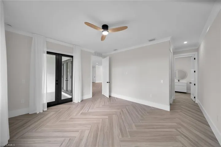 Unfurnished bedroom featuring visible vents, baseboards, ornamental molding, access to exterior, and french doors