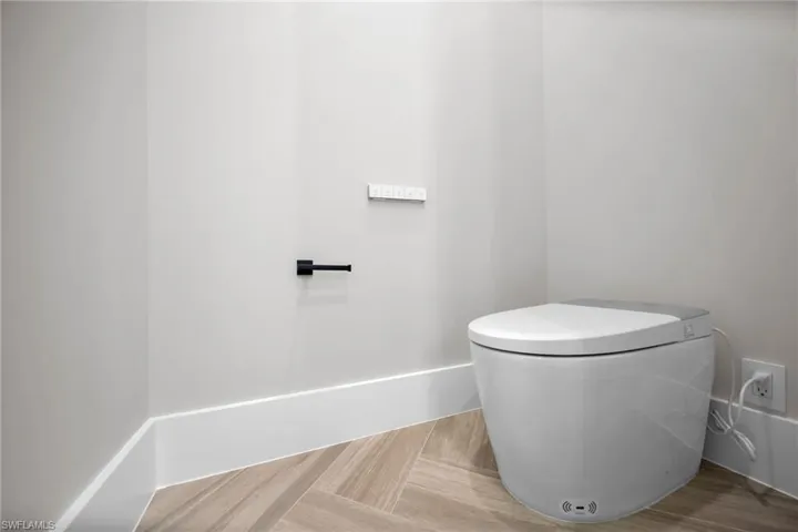 Bathroom with toilet and wood finished floors
