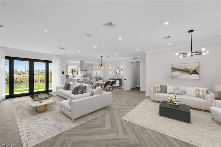 Living area with recessed lighting, visible vents, and a notable chandelier