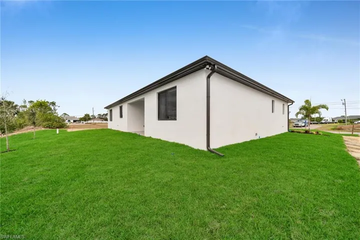View of property exterior featuring a lawn and stucco siding