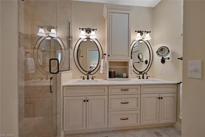 Full bathroom featuring double vanity and a shower stall