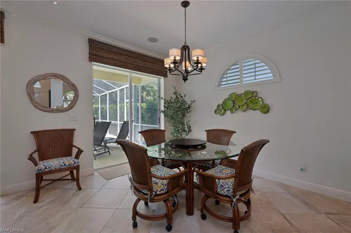 Dining room featuring crown molding, plenty of natural light, a chandelier, and a sunroom