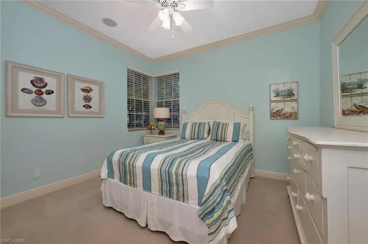 Bedroom with crown molding, light colored carpet, and a ceiling fan