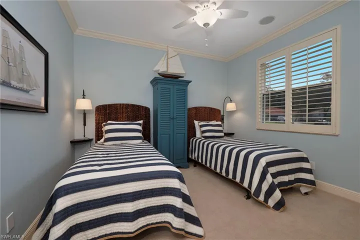 Bedroom with crown molding, light colored carpet, and a ceiling fan