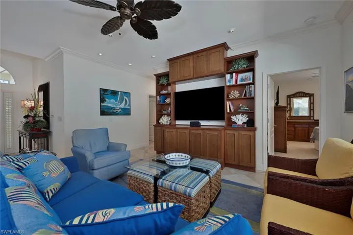 Living room with crown molding and a ceiling fan