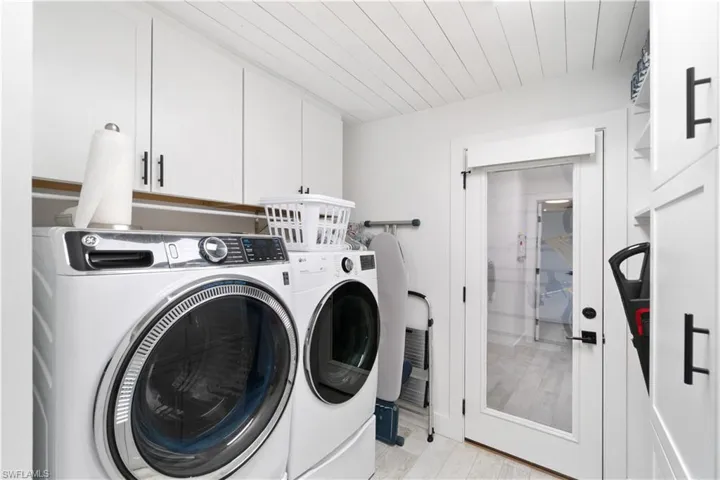 Laundry area with washing machine and dryer and cabinets