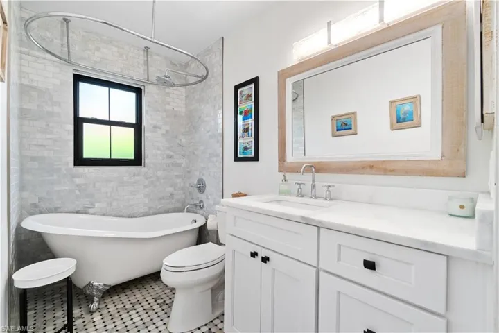 Full bathroom with plus walk in shower, toilet, tile patterned flooring, vanity, and tile walls