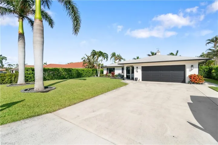 Ranch-style house with a front lawn and a garage