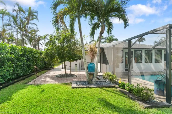 View of yard with a patio and glass enclosure
