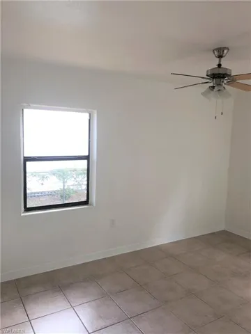 Unfurnished room with ceiling fan and light tile patterned floors