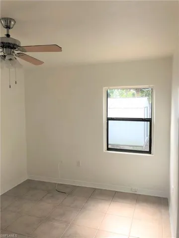 Unfurnished room with a ceiling fan and light tile patterned floors