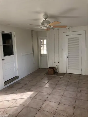 Foyer entrance with a ceiling fan and light tile patterned flooring