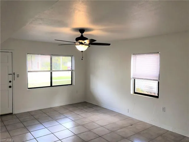 Spare room with ceiling fan and light tile patterned floors