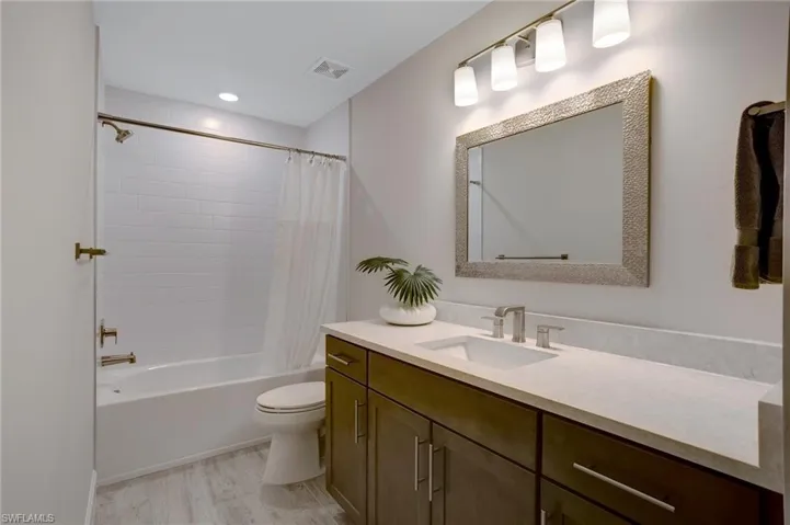 Full bathroom featuring vanity, shower / bath combo, and wood finished floors