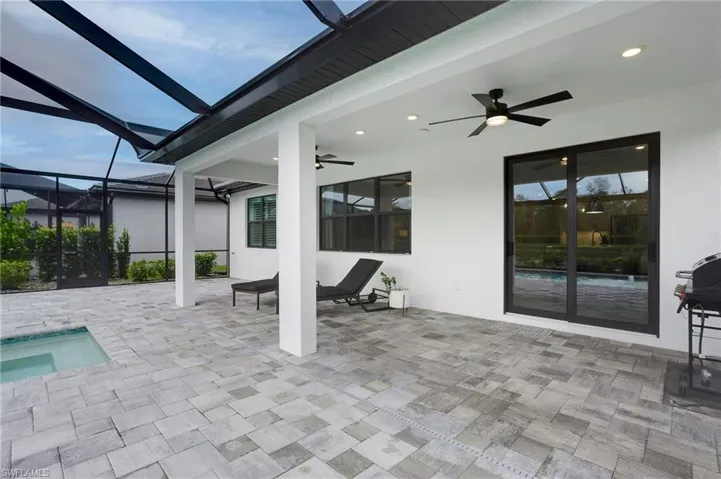 View of patio with a ceiling fan, an outdoor pool, and a lanai