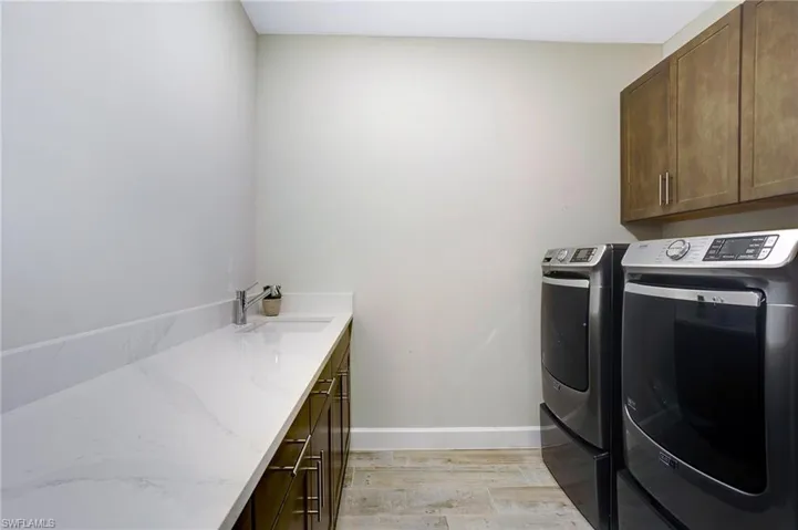 Laundry area featuring cabinet space, separate washer and dryer, and light wood-style flooring