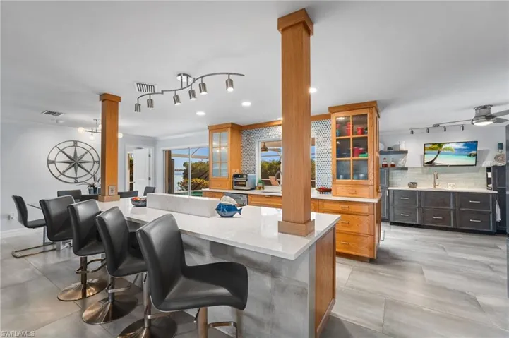 Kitchen boasts quartz countertops, fabulous backsplash. There is a morning kitchen in the background.