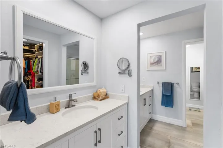 Separate vanities with quartz countertops.