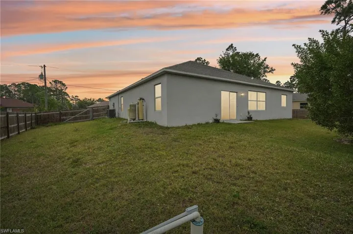 Back of property with a yard, a fenced backyard, and stucco siding