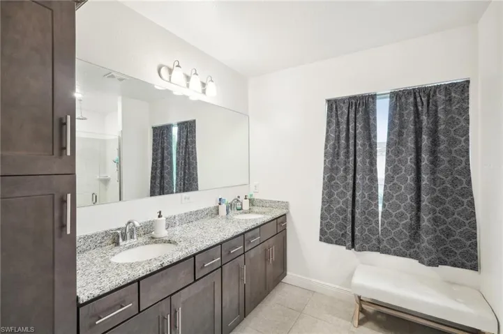 Full bath with tile patterned floors, baseboards, visible vents, and a sink
