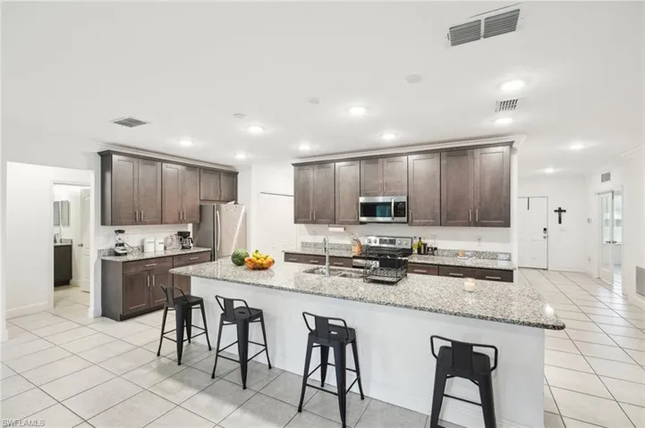 Kitchen featuring a sink, visible vents, appliances with stainless steel finishes, and a breakfast bar area