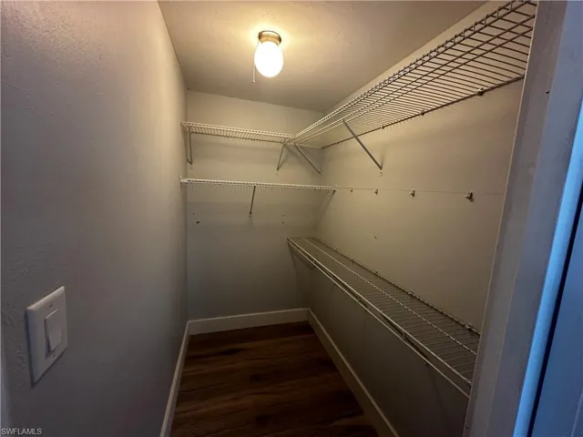 Walk in closet featuring dark wood finished floors