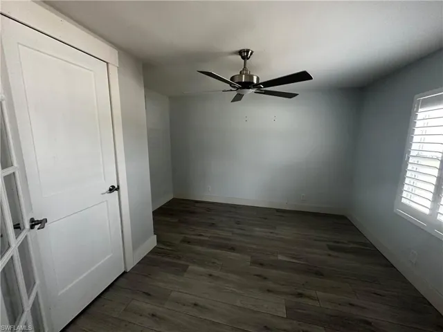 Unfurnished bedroom with dark wood-style floors and ceiling fan