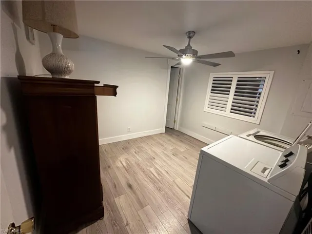 Laundry area with light wood-type flooring, ceiling fan, and washer and dryer