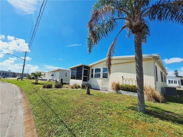 View of home's exterior featuring a yard, central AC, and a sunroom