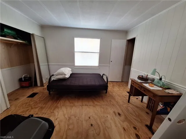 Bedroom featuring crown molding and wood finished floors