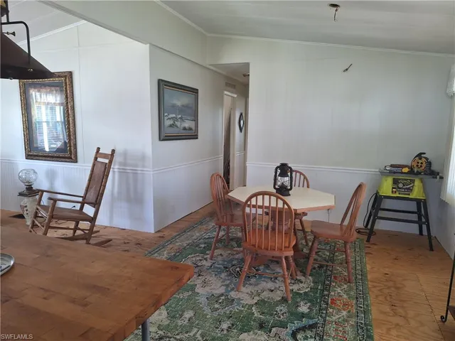 Dining area with crown molding and wood finished floors