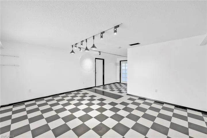 Spare room featuring tile patterned floors, a textured ceiling, and track lighting