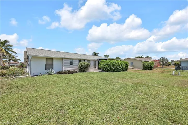 Back of property with a yard and stucco siding