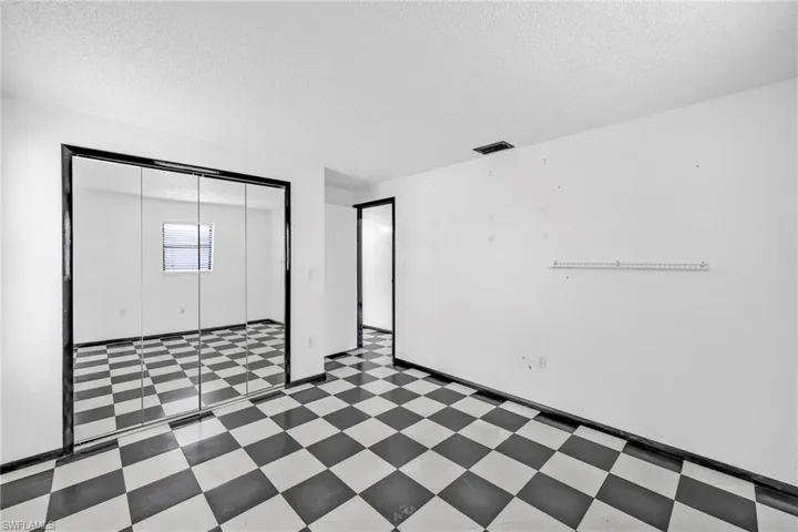 Unfurnished bedroom with tile patterned floors, a textured ceiling, and a closet