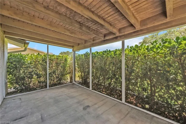 Unfurnished sunroom featuring beam ceiling