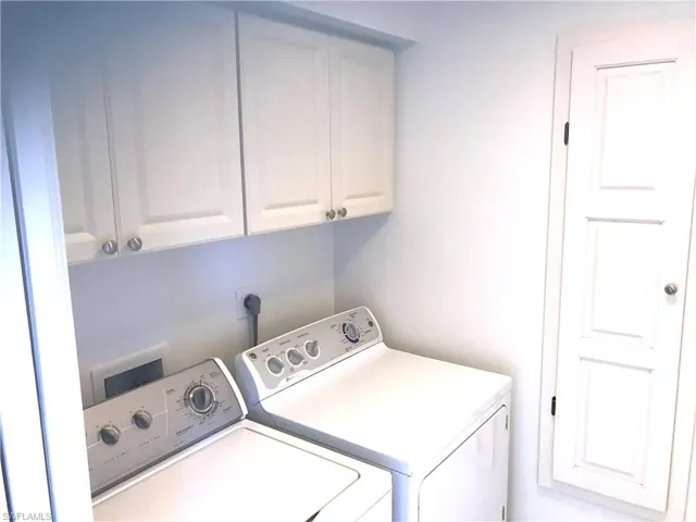 Laundry room featuring cabinet space and washer and clothes dryer