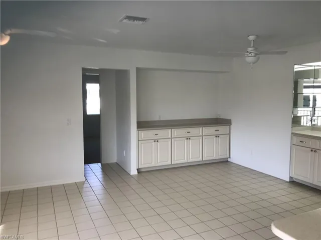 Unfurnished room with ceiling fan and light tile patterned floors