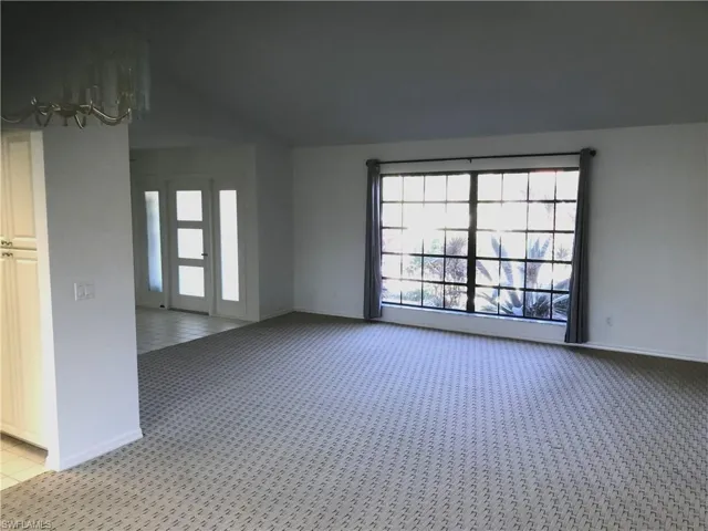 Empty room with healthy amount of natural light and light colored carpet