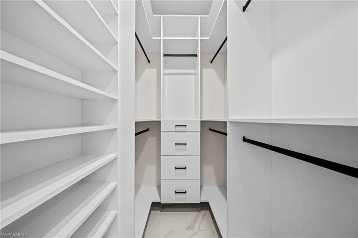 Spacious closet featuring marble look tile flooring