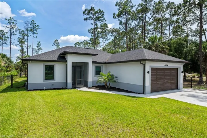 View of front of house featuring stucco siding, a garage, driveway, and a shingled roof